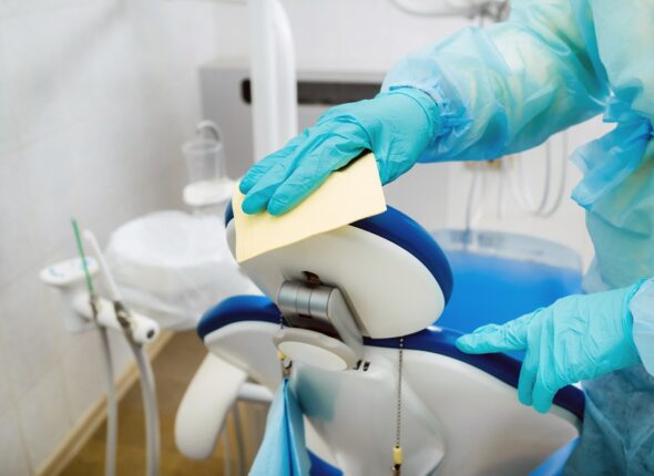 A nurse disinfects work surfaces in the dentist's office.